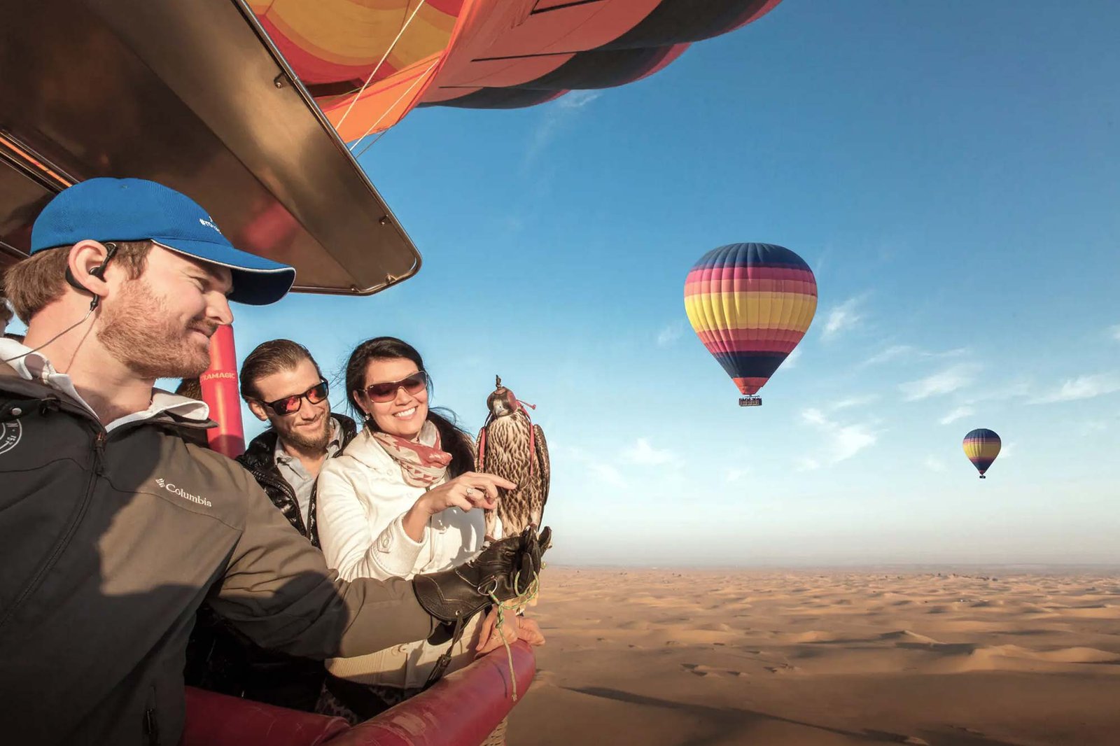 Hot air balloon floating over golden dunes